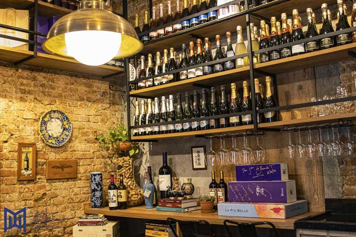 uma sala com prateleiras de garrafas e copos de vinho